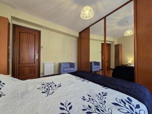 サンタンデールにあるAPARTAMENTO FAMILIAR Centrico Grupo RH-72のベッドルーム1室(大型ベッド1台、青い椅子2脚付)