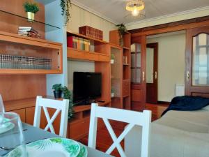 サンタンデールにあるAPARTAMENTO FAMILIAR Centrico Grupo RH-72のベッド1台、椅子2脚、テレビが備わる客室です。