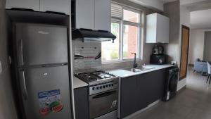 a kitchen with a refrigerator and a stove top oven at Spacious Apartment in Central Area in Kigali