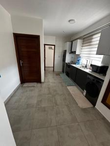 a kitchen with a door and a kitchen with a tile floor at Spacious Apartment in Central Area in Kigali +7 photos