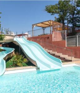 eine Wasserrutsche in einem Schwimmbad in der Unterkunft Mobilhome 6 places Domaine de Chaussy in Lagorce