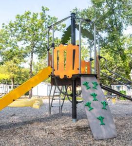 ein Spielplatz mit einer orangenen und einer gelben Rutsche in der Unterkunft Mobilhome 6 places Domaine de Chaussy in Lagorce