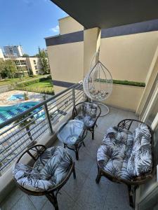 3 sillas y un columpio en el balcón en Дрийм 2 Мечта 2, en Sunny Beach