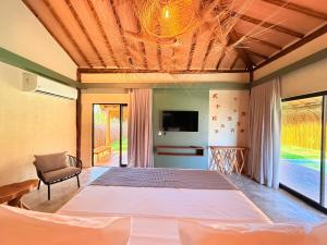 ein Schlafzimmer mit großem Bett und Fernseher in der Unterkunft Naca Boutique Hotel in Pôrto de Pedras + 40 Fotos