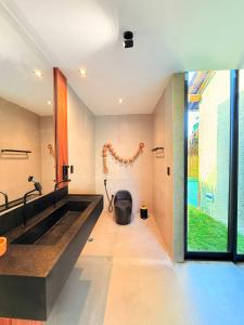 ein Badezimmer mit einem großen Waschbecken und einem großen Fenster in der Unterkunft Naca Boutique Hotel in Pôrto de Pedras