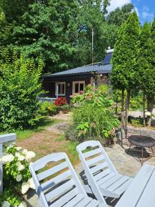 two white chairs and a table in front of a house at To Tu in Ruciane-Nida