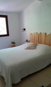 un grande letto bianco in una camera da letto con finestra di Terra Corsa Duplex T2 a Porto Ota Altre 40 foto