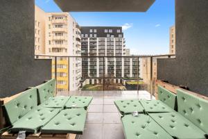 a balcony with green chairs and a view of a building at Lumina I 3BR Apartment with Balcony I Parking I 2 Bathrooms I near Center in Warsaw