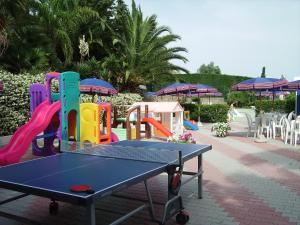 a ping pong table in front of a playground at Residence La Carruba in Diano Marina