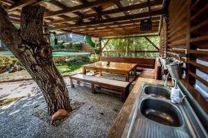 a kitchen with a tree and a table and a sink at Стальовата Къща - Stalyovata Guest House - Private Pool, Jacuzzi & Sauna in Prokhod