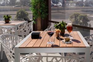 a wooden table with two glasses of wine on a balcony at Catalonia Málaga in Málaga