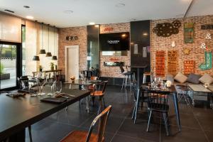 a restaurant with tables and chairs and a brick wall at Catalonia Málaga in Málaga
