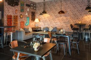 a restaurant with tables and chairs and a brick wall at Catalonia Málaga in Málaga