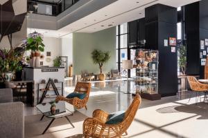 a lobby with wicker chairs and tables in a store at Catalonia Málaga in Málaga