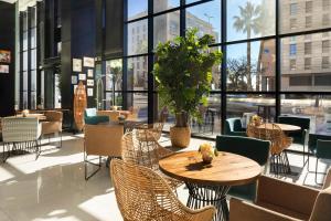 a restaurant with tables and chairs and a large window at Catalonia Málaga in Málaga