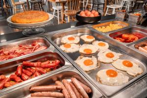 a buffet with eggs sausage and other breakfast foods at Catalonia Málaga in Málaga