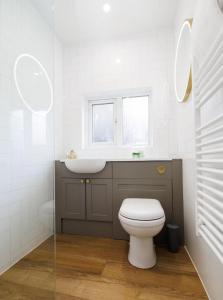 a bathroom with a toilet and a sink and a window at Stylish 1-Bed Apartment in the Heritage Quarter in Dunfermline