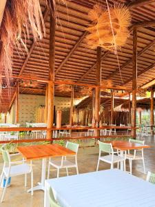 einen Pavillon mit Tischen und Stühlen unter einer Holzdecke in der Unterkunft Naca Boutique Hotel in Pôrto de Pedras