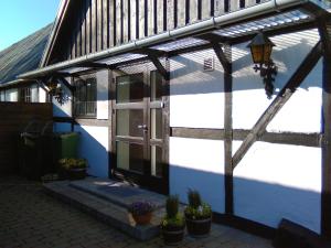 un edificio azul y blanco con puerta y macetas en Dåstrup Bed & Breakfast, en Viby