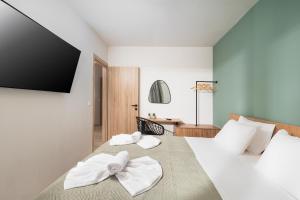 a bedroom with two white towels on a bed at Makas Beach Suites II in Hersonissos