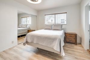 a white bedroom with a bed and a mirror at 8 Mi to Dtwn Home with Fireplace and Games in LA! in Los Angeles