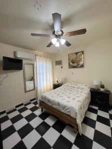 a bedroom with a ceiling fan and a checkered floor at Casa esmeralda in Monclova