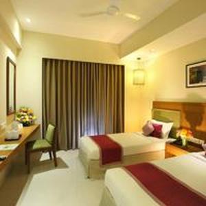 a hotel room with two beds and a desk at Jk Park Residency Perambra in Mennānyam