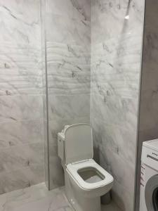 a white bathroom with a toilet and a shower at Komfort House in Tbilisi City
