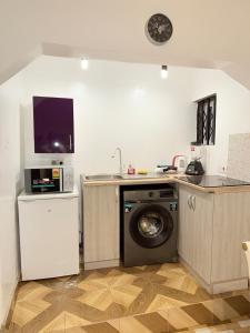 a kitchen with a washing machine and a microwave at The Modern Hideaway 10km from Airport in Madina