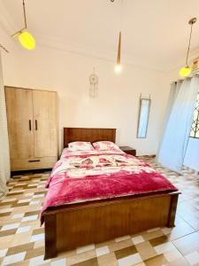 a bedroom with a large bed with a red blanket at The Modern Hideaway 10km from Airport in Madina +19 photos