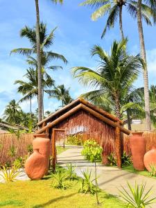 ein Resort mit Palmen im Hintergrund in der Unterkunft Naca Boutique Hotel in Pôrto de Pedras