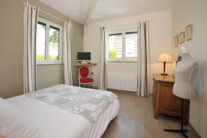 um quarto com uma cama e uma secretária com uma cómoda em La Rosace em Chartres
