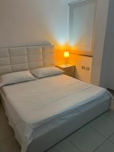 a bedroom with a large white bed with a lamp at Sea view apartment! in Vlorë