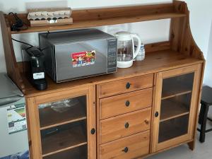 Un four micro-ondes est installé au-dessus d'une armoire en bois. dans l'établissement Azzam's Apartments, à Médine