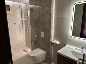 une salle de bains avec douche, toilettes et lavabo dans l'établissement Azzam's Apartments, à Médine