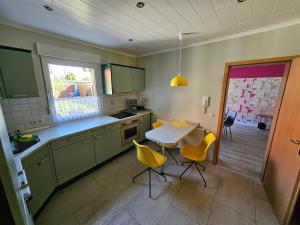 a kitchen with a table and yellow chairs in it at Ferienwohnung Hanni in Gräfenhainichen