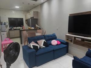 a living room with a blue couch with pillows at Casa Completa para RRS in Ji-Paraná