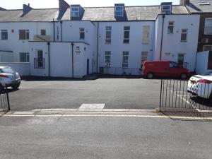 a parking lot in front of a white building at Three bedroom apartment Darlington Victoria Road in Darlington
