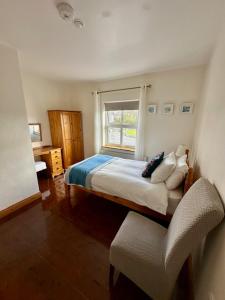 una camera con un letto, una finestra e una sedia di Nellie Dee's - Room Only a Doolin