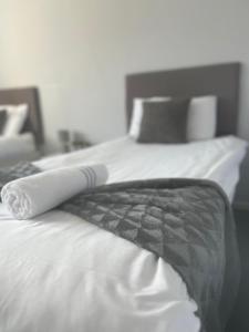 Una cama con una manta blanca y negra encima. en Glenrothes Central Apartment, en Glenrothes