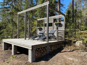 due sedie sedute su un ponte di legno con vetro di Sauna cottage in Nuuksio a Espoo
