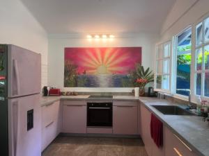 a kitchen with a large painting on the wall at Wonderland Villa in Petit-Bourg