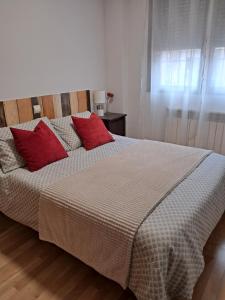 a bedroom with a bed with red pillows on it at El Rincon La Roca in El Espinar