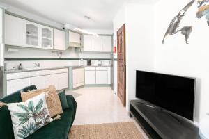 a living room with a flat screen tv and a couch at Vila Florida - T2 familiar perto da praia in São Martinho do Porto +9 photos