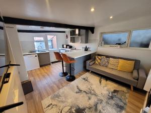 a living room with a couch and a kitchen at City Centre Wallgate Apartments- Step back into Roman history in Colchester