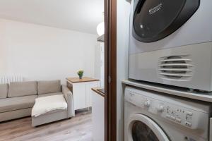 a living room with a washing machine and a couch at Monolocale - Piano terra - Ingresso indipendente in Padova