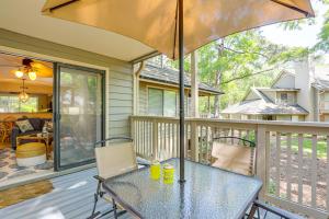 a table and chairs on a porch with an umbrella at Private Deck & Pool Access: Myrtle Beach Getaway! in Myrtle Beach
