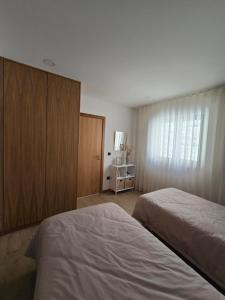 1 Schlafzimmer mit 2 Betten, einem Schrank und einem Fenster in der Unterkunft Vivenda Branca Martinho II in Peso da Régua + 12 Fotos