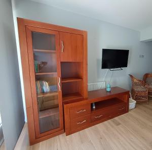 a wooden cabinet with a tv and a wooden table at Casa Filo in Redondela