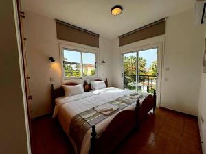a bedroom with a large bed and two windows at Villa Solmare in Pervolia +15 photos
